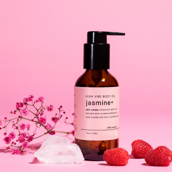 High Vibe Jasmine Body Oil displayed with raspberries and clear quartz crystal, emphasizing natural and gem elixir ingredients.