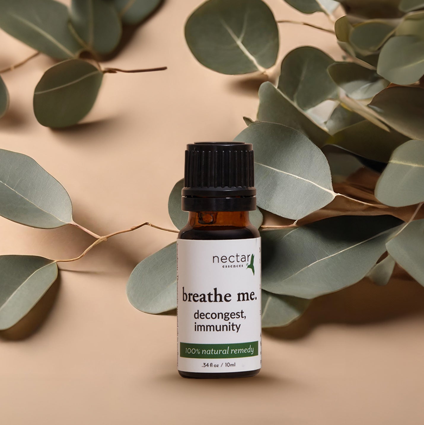 A bottel of "Breathe me" product decongest, immunity essential oil with background leaves and beige color