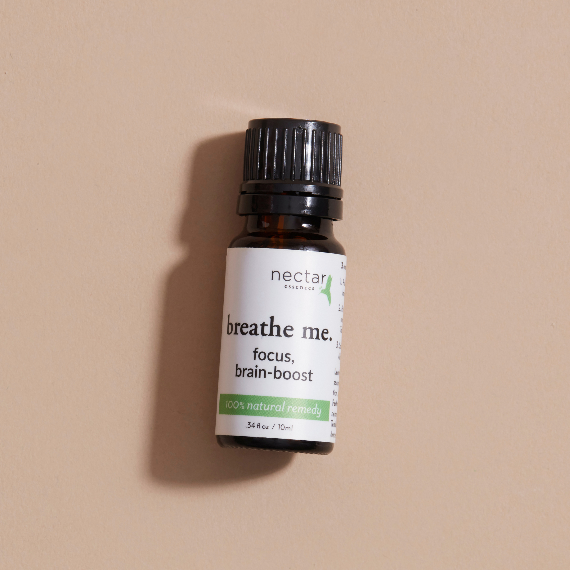 Bottle of 'breathe me' focus brain-boost supplement laying on a beige background