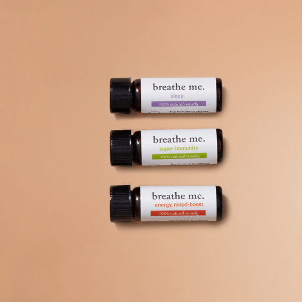 A trlo bottels lay horizental on biege background, essential oil small bottles of breathe me jetsetter kit