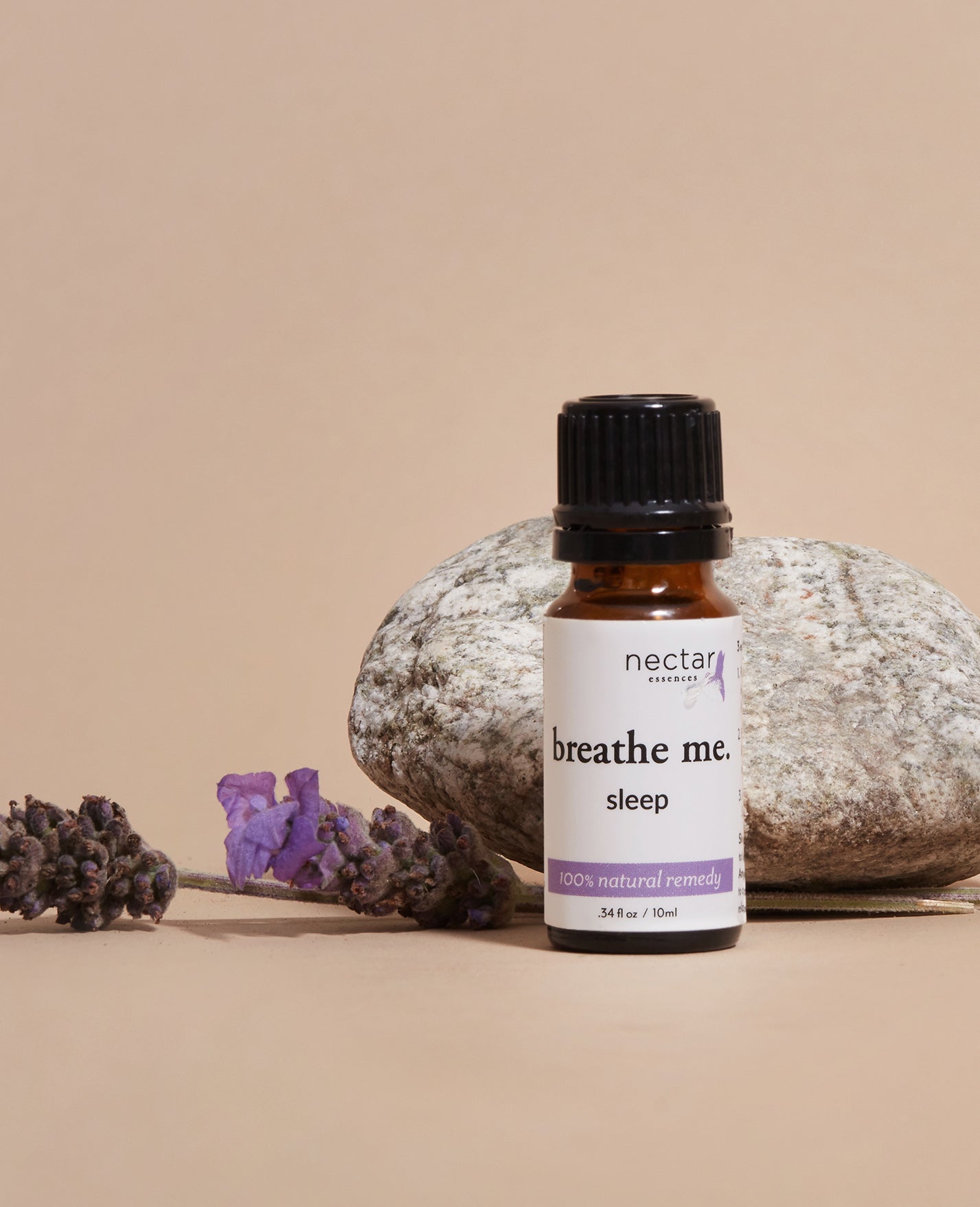 Nectar Aromatics 'breathe me. sleep' essential oil bottle with lavender and a rock on a beige background