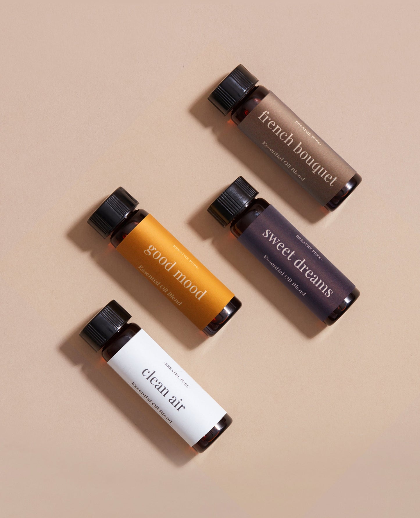 This image features a collection of four essential oil bottles arranged neatly on a neutral background. Each bottle is distinctively labeled and colored to represent different scents or varieties within the "full spectrum diffuser oil kit, vol.