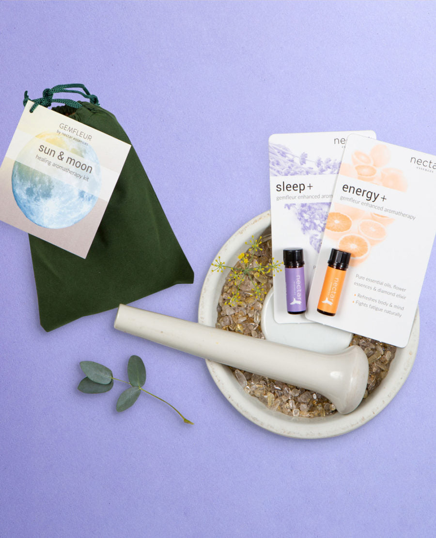 A product set including a green bag, a white mortar and pestle, a small bottle of lavender essential oil, and cards labeled 'sun & moon' and 'sleep+' on a purple background.