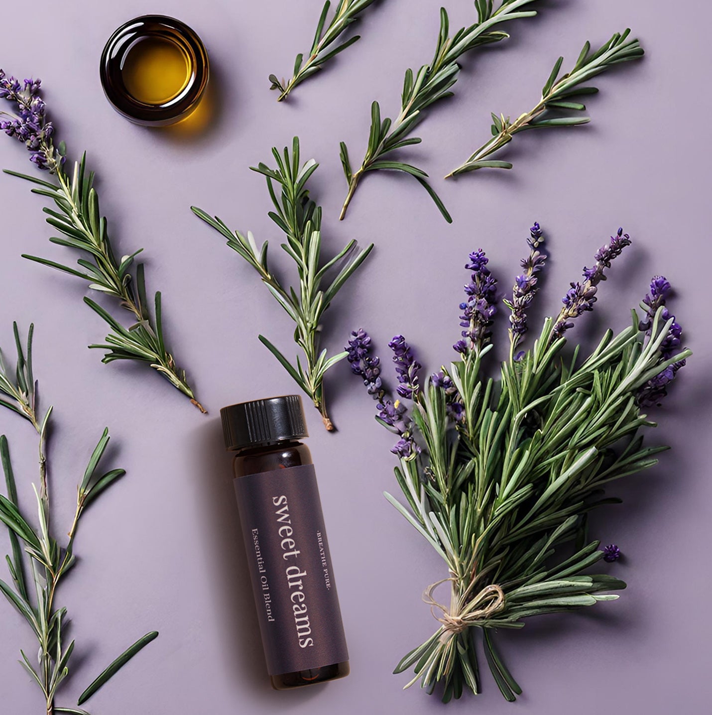 A bottle of 'Sweet Dreams Diffuser Oil' with lavender and rosemary branches around it, presented on a purple background.