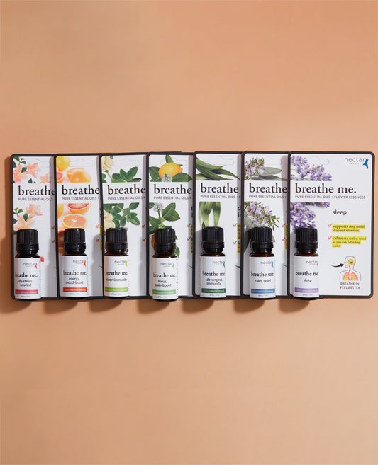 A set of seven essential oil bottles, each with a different color label, displayed against a beige background.