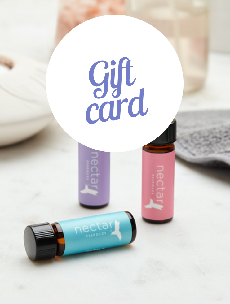 Three essential oil bottles in blue, purple, and pink colors, labeled 'Gift Card' indicating they are part of a gift package.